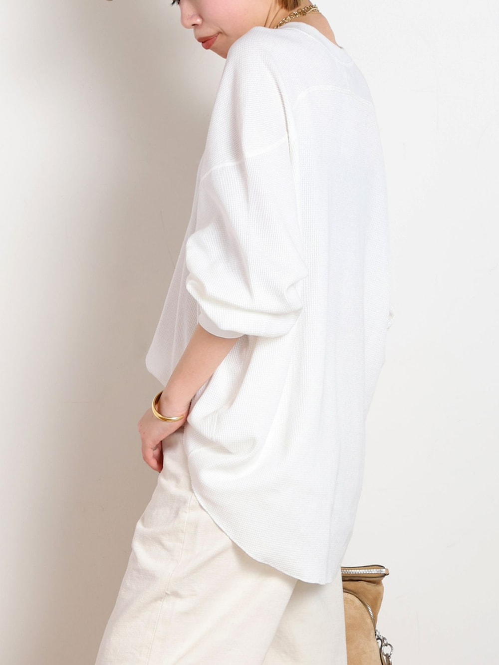 ホワイト系のデニムパンツ、ホワイト系のTシャツ/カットソー、ゴールド系のブレスレットを着用したレディースの冬コーディネートの5枚目の写真