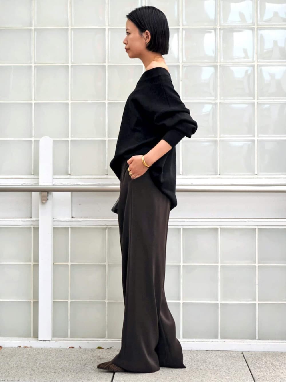 ブラック系のニット/セーター、ブラウン系のスラックス、イエロー系のブーツを着用したレディースの秋コーディネートの2枚目の写真