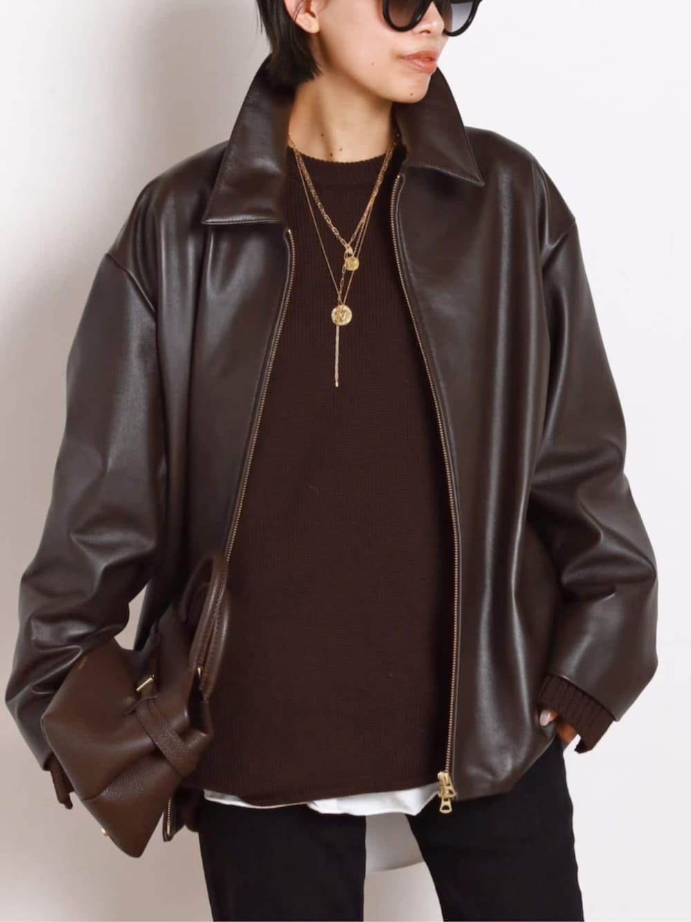 ブラック系のブーツ、ブラウン系のその他アウター、ブラウン系のトートバッグを着用したレディースの秋コーディネートの7枚目の写真