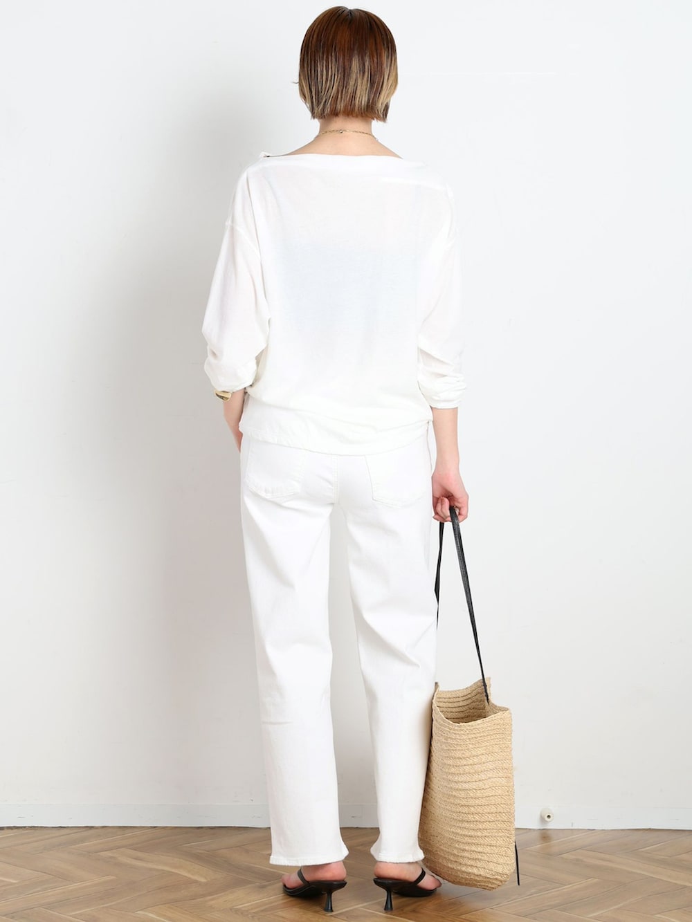 ホワイト系のデニムパンツ、ホワイト系のTシャツ/カットソー、ベージュ系のトートバッグを着用したレディースの春コーディネートの4枚目の写真