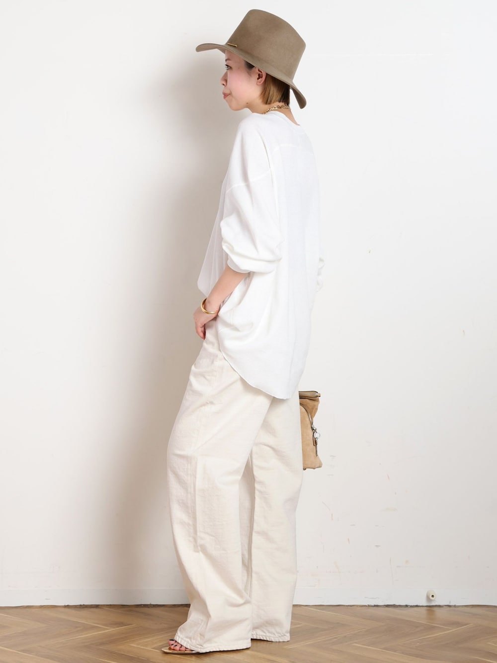 ホワイト系のデニムパンツ、ホワイト系のTシャツ/カットソー、ゴールド系のブレスレットを着用したレディースの冬コーディネートの2枚目の写真