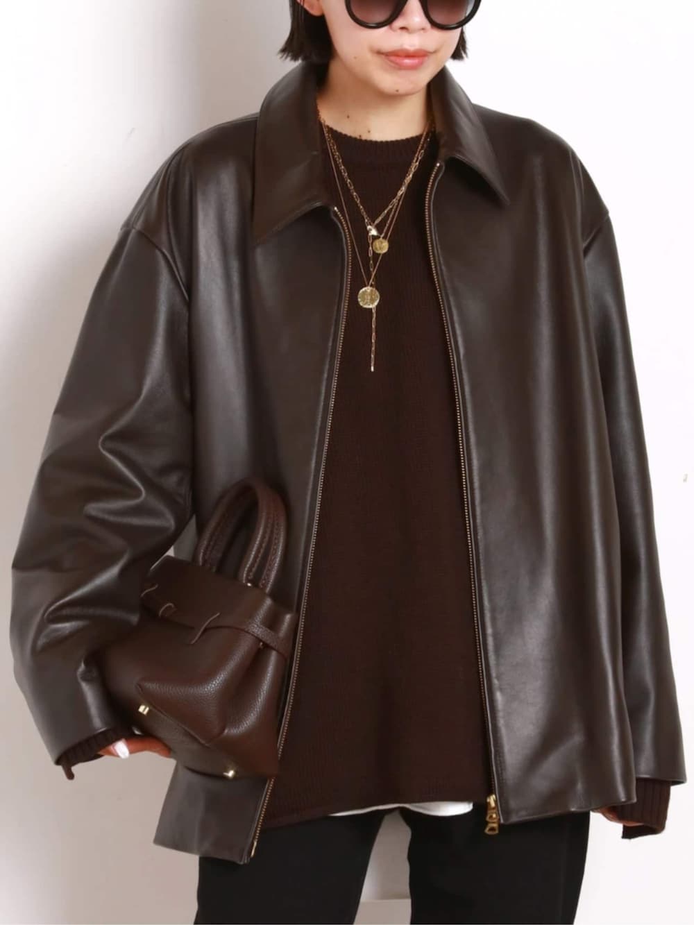 ブラック系のブーツ、ブラウン系のその他アウター、ブラウン系のトートバッグを着用したレディースの秋コーディネートの4枚目の写真