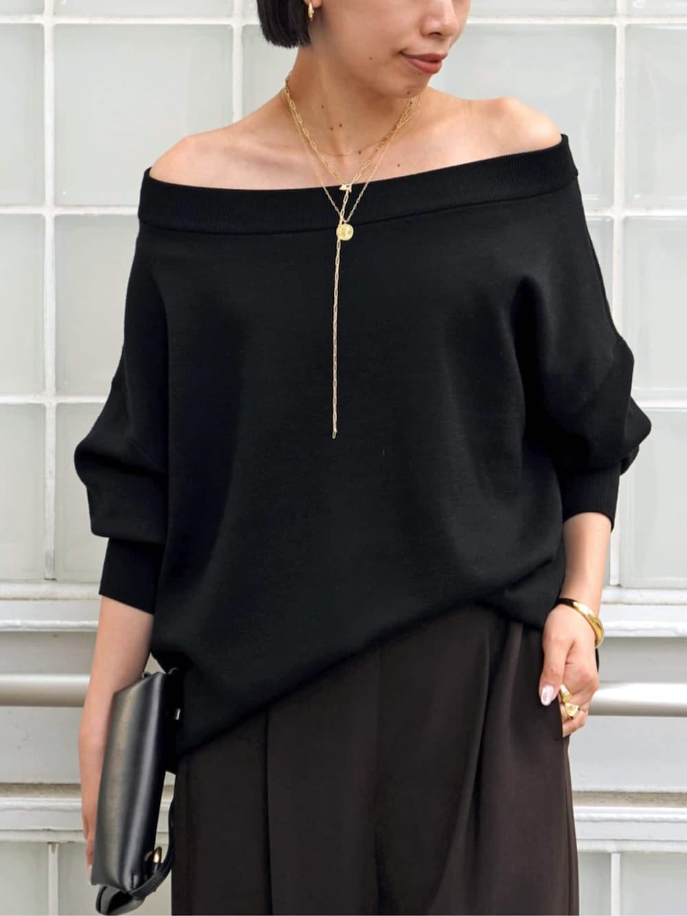 ブラック系のニット/セーター、ブラウン系のスラックス、イエロー系のブーツを着用したレディースの秋コーディネートの4枚目の写真