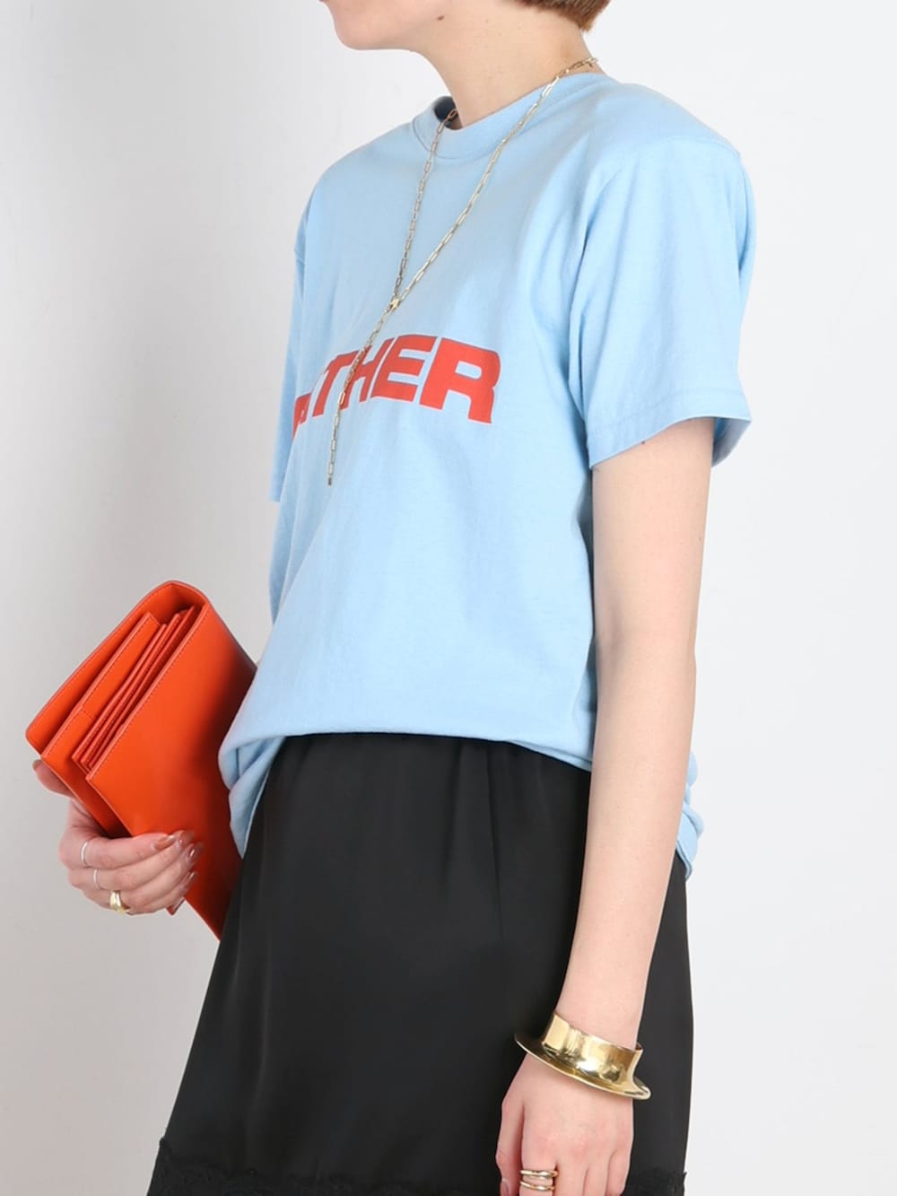ブラック系のスカート、ブルー系のTシャツ/カットソー、ブルー系のスニーカーを着用したレディースの春コーディネートの5枚目の写真