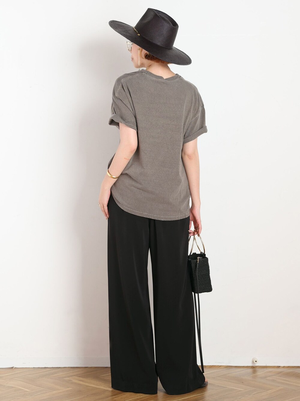 ブラック系のスラックス、グリーン系のTシャツ/カットソー、ブラック系のショルダーバッグを着用したレディースの夏コーディネートの3枚目の写真