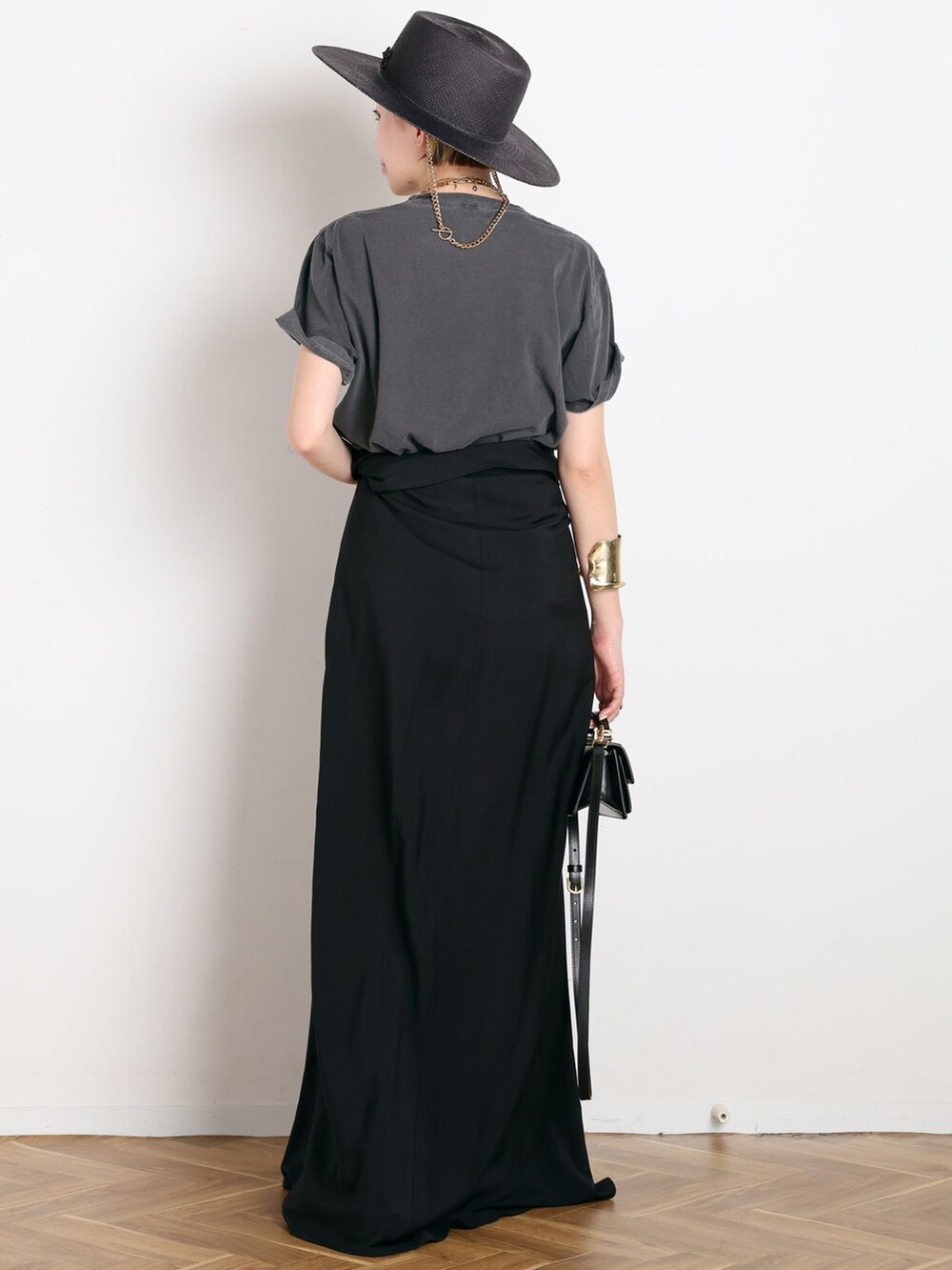 ブラック系のワンピース、ブラック系のTシャツ/カットソー、ブラウン系のサンダルを着用したレディースの春コーディネートの3枚目の写真