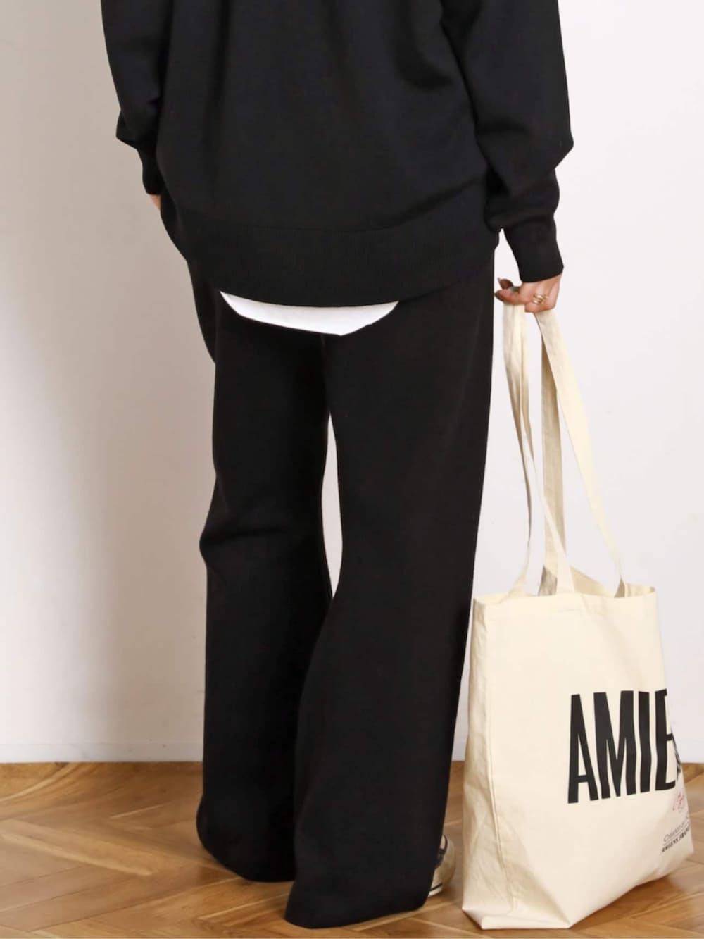 ホワイト系のTシャツ/カットソー、ブラック系のその他パンツ、ブラック系のダウンジャケット/コートを着用したレディースの秋コーディネートの6枚目の写真