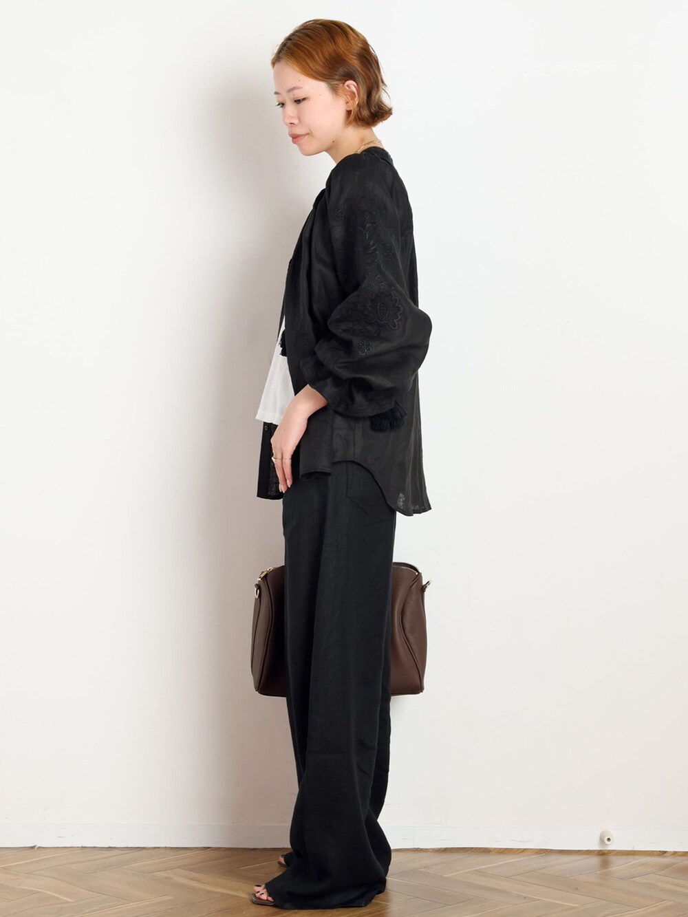 ブラック系のその他パンツ、ブラック系のシャツ/ブラウス、ブラウン系のボストンバッグを着用したレディースの夏コーディネートの2枚目の写真