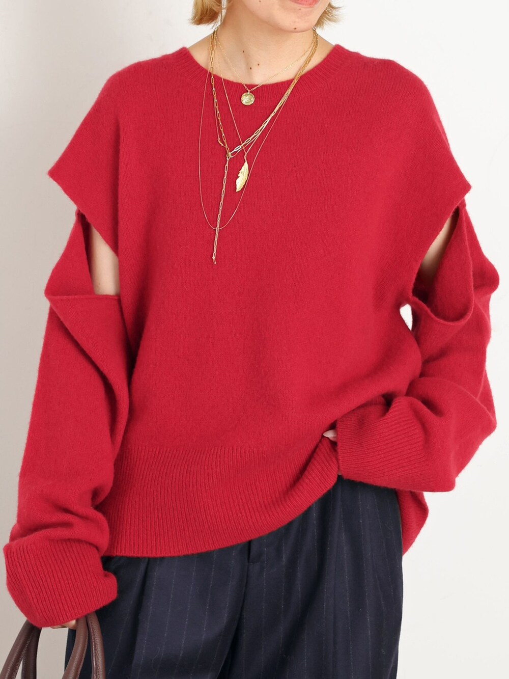 ブルー系のスラックス、レッド系のニット/セーターを着用したレディースの秋コーディネートの4枚目の写真