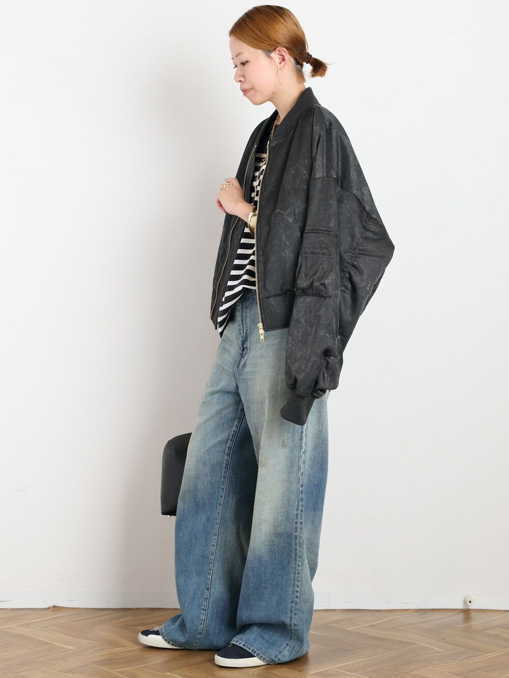 ブルー系のデニムパンツ、ブラック系のTシャツ/カットソー、ゴールド系のリングを着用したレディースの夏コーディネートの2枚目の写真