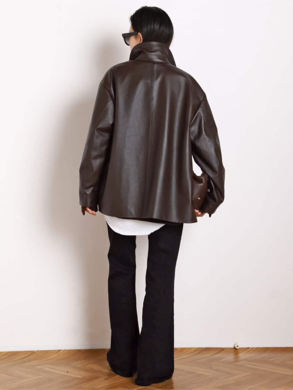 ブラック系のブーツ、ブラウン系のその他アウター、ブラウン系のトートバッグを着用したレディースの秋コーディネートの3枚目の写真