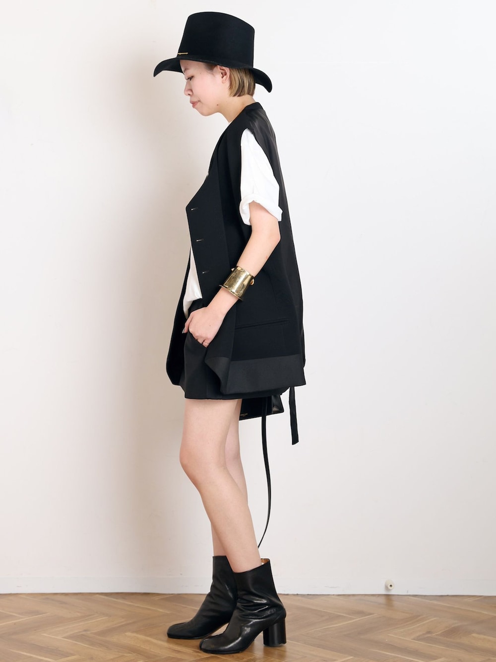 ブラック系のスーツベスト、ブラック系のその他パンツ、ホワイト系のTシャツ/カットソーを着用したレディースの冬コーディネートの2枚目の写真