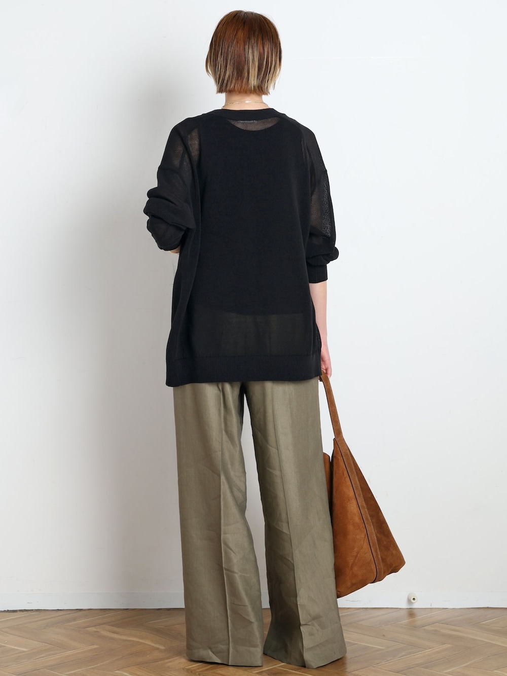 グリーン系のスラックス、ブラック系のTシャツ/カットソー、ブラック系のカーディガン/ボレロを着用したレディースの春コーディネートの3枚目の写真