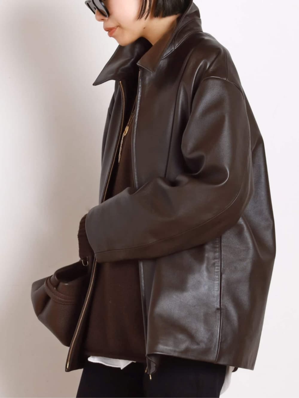 ブラック系のブーツ、ブラウン系のその他アウター、ブラウン系のトートバッグを着用したレディースの秋コーディネートの5枚目の写真