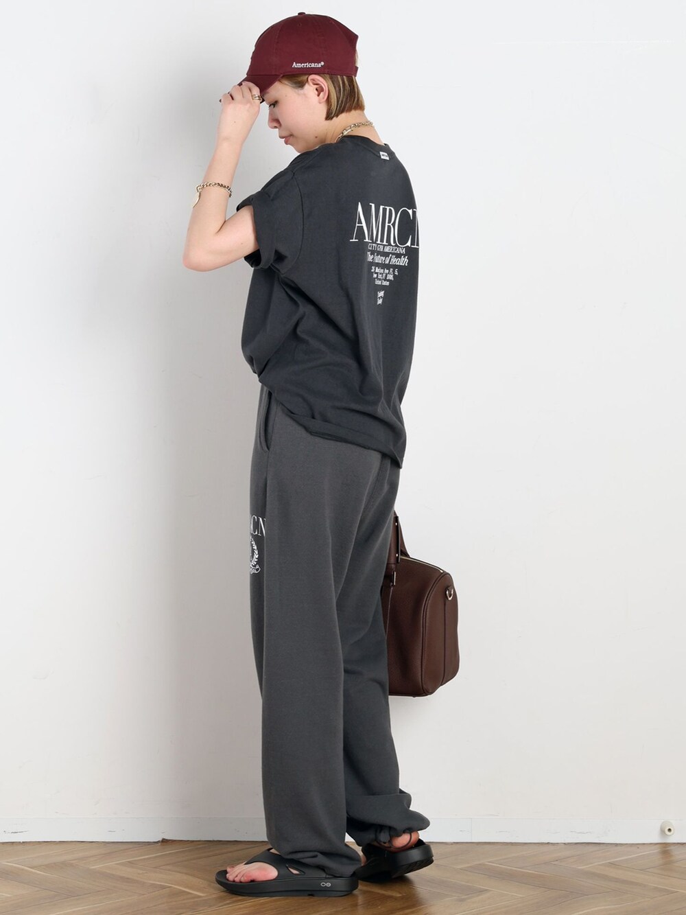 ブラック系のスウェットパンツ、ブラック系のTシャツ/カットソー、ゴールド系のネックレスを着用したレディースの春コーディネートの2枚目の写真