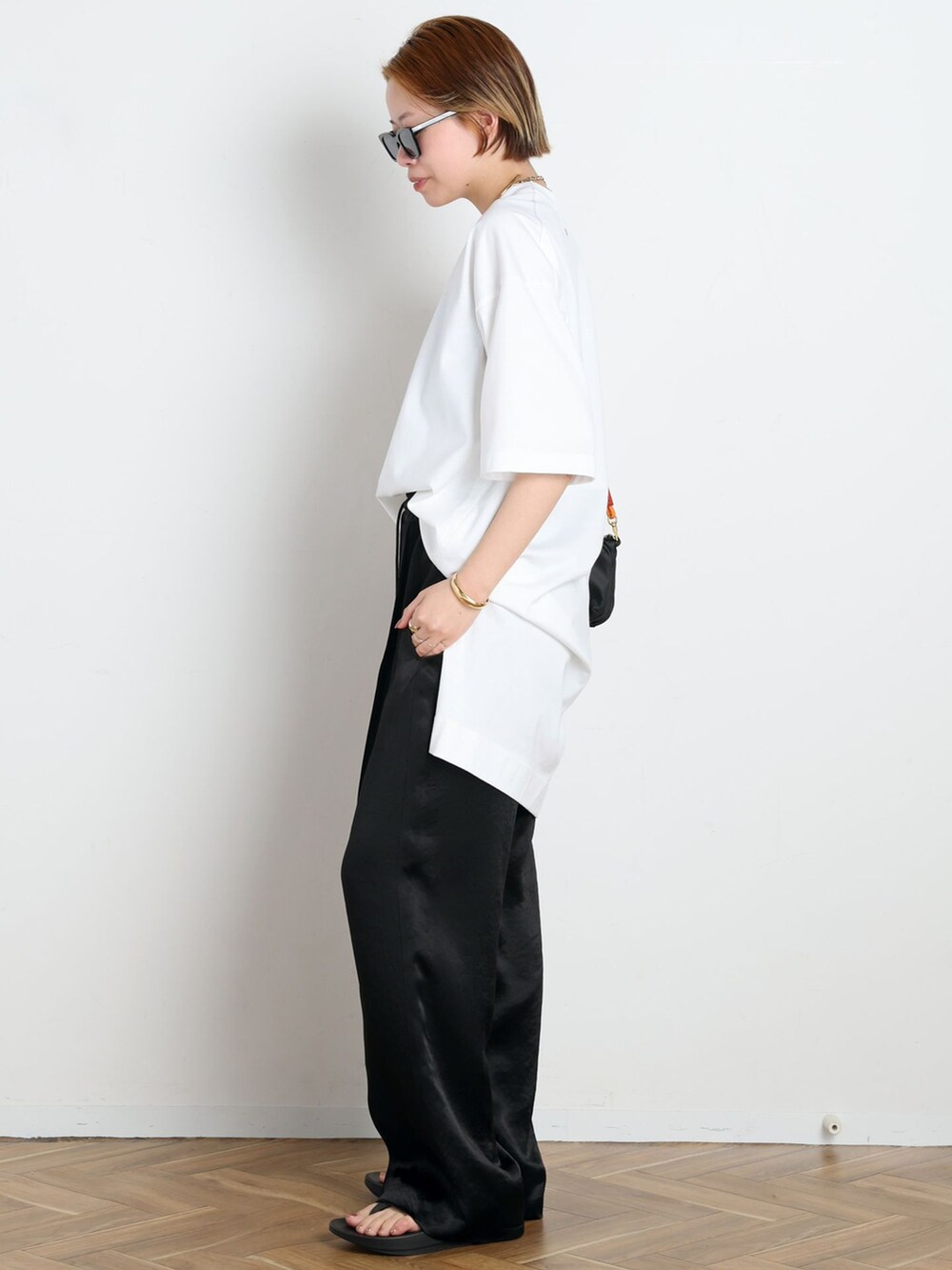 ブラック系のその他パンツ、ホワイト系のTシャツ/カットソー、ブラック系のショルダーバッグを着用したレディースの春コーディネートの2枚目の写真