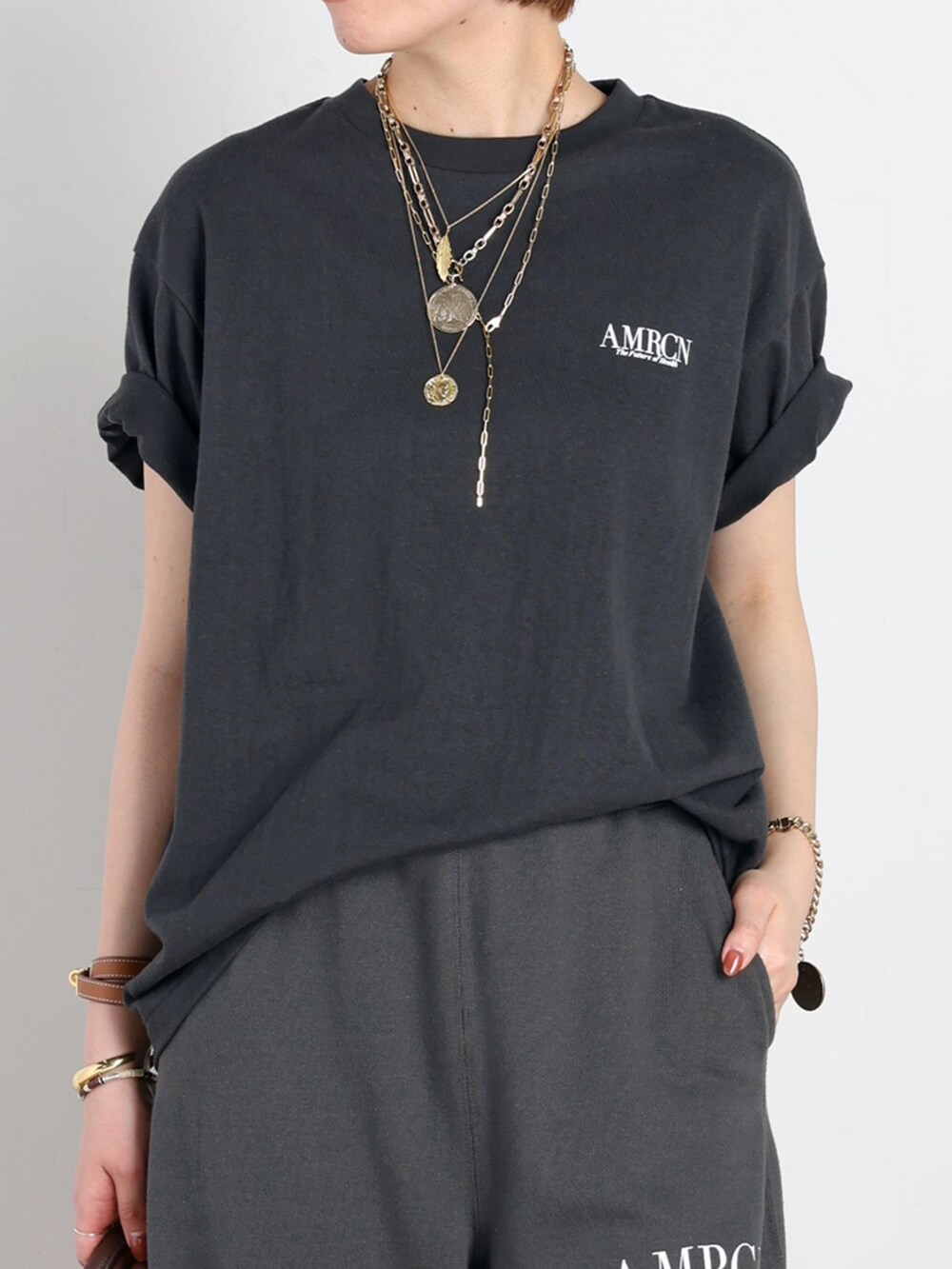 ブラック系のスウェットパンツ、ブラック系のTシャツ/カットソー、ゴールド系のネックレスを着用したレディースの春コーディネートの4枚目の写真
