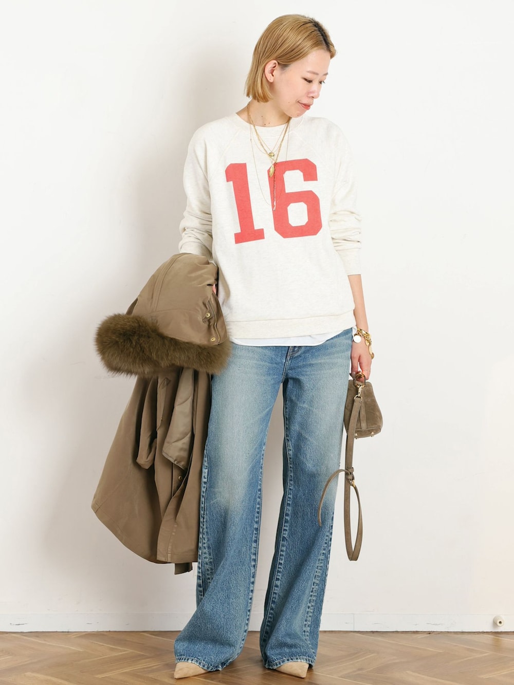 イエロー系のその他アウター、ブルー系のデニムパンツ、ホワイト系のTシャツ/カットソーを着用したレディースの秋コーディネートの4枚目の写真