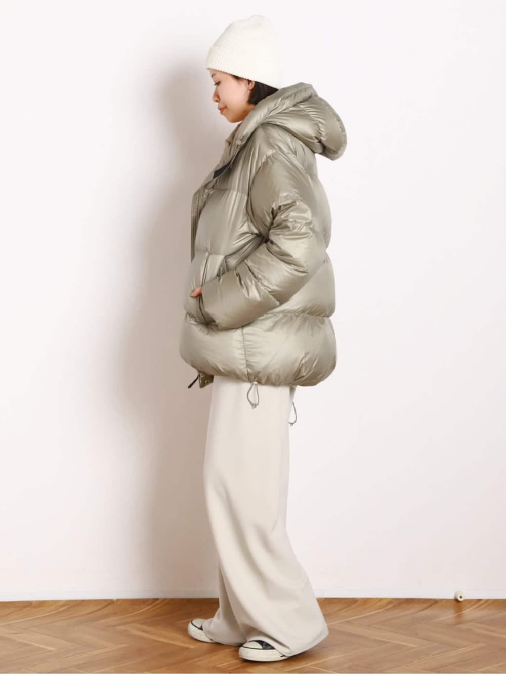 ベージュ系のダウンジャケット/コート、ホワイト系のスラックスを着用したレディースの秋コーディネートの2枚目の写真