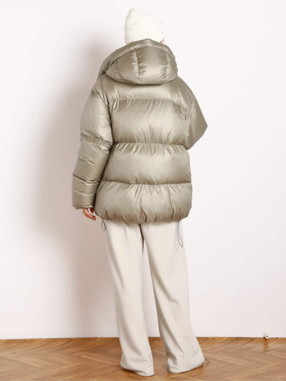 ベージュ系のダウンジャケット/コート、ホワイト系のスラックスを着用したレディースの秋コーディネートの3枚目の写真