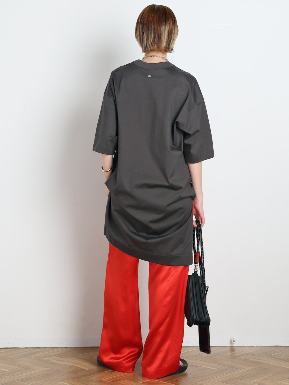 レッド系のその他パンツ、グレー系のTシャツ/カットソー、ブラック系のショルダーバッグを着用したレディースの春コーディネートの3枚目の写真