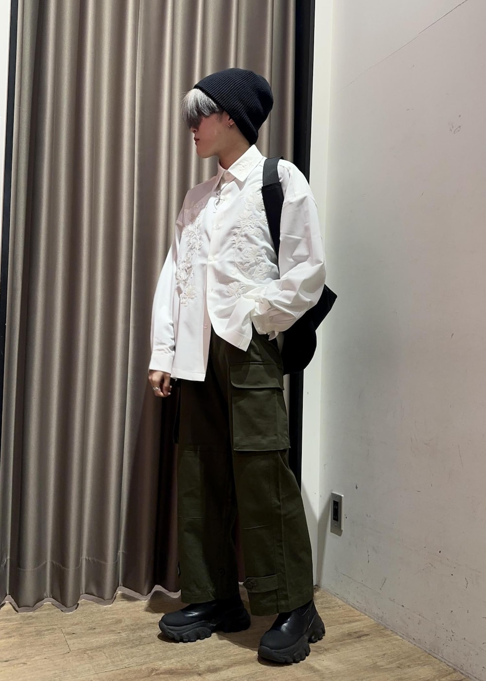 グリーン系のカーゴパンツ、ブラック系のメッセンジャーバッグ、ホワイト系のシャツ/ブラウスを着用したメンズの冬コーディネートの4枚目の写真