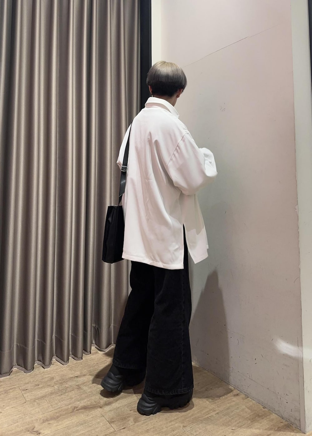 ブラック系のショルダーバッグ、ブラック系のスウェット、ブラック系のデニムパンツを着用したメンズの冬コーディネートの4枚目の写真