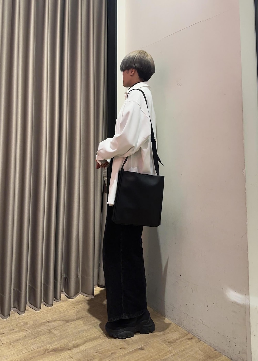 ブラック系のショルダーバッグ、ブラック系のスウェット、ブラック系のデニムパンツを着用したメンズの冬コーディネートの2枚目の写真