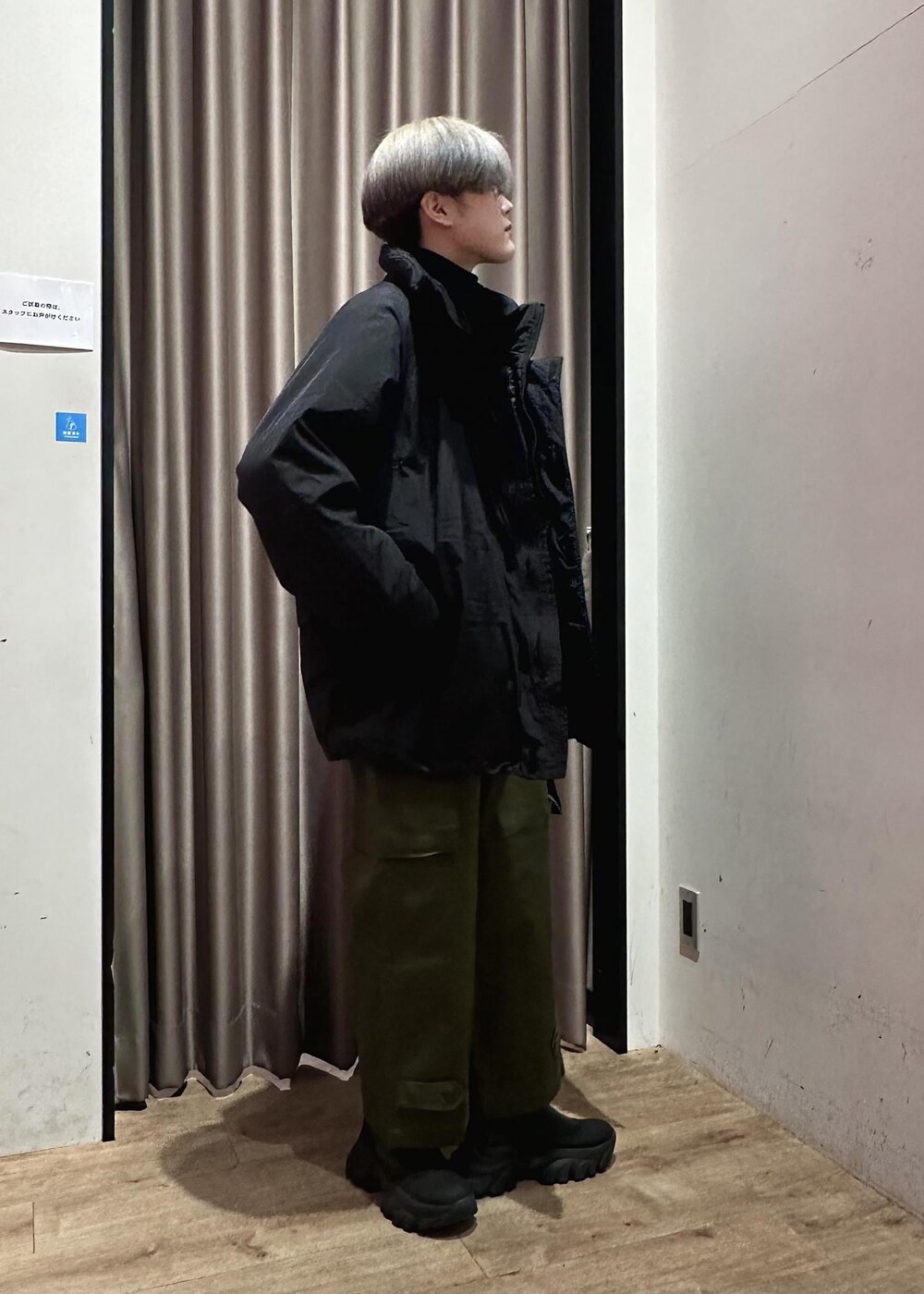 ブラック系のニット/セーター、グリーン系のカーゴパンツ、ブラック系のブルゾンを着用したメンズの冬コーディネートの2枚目の写真