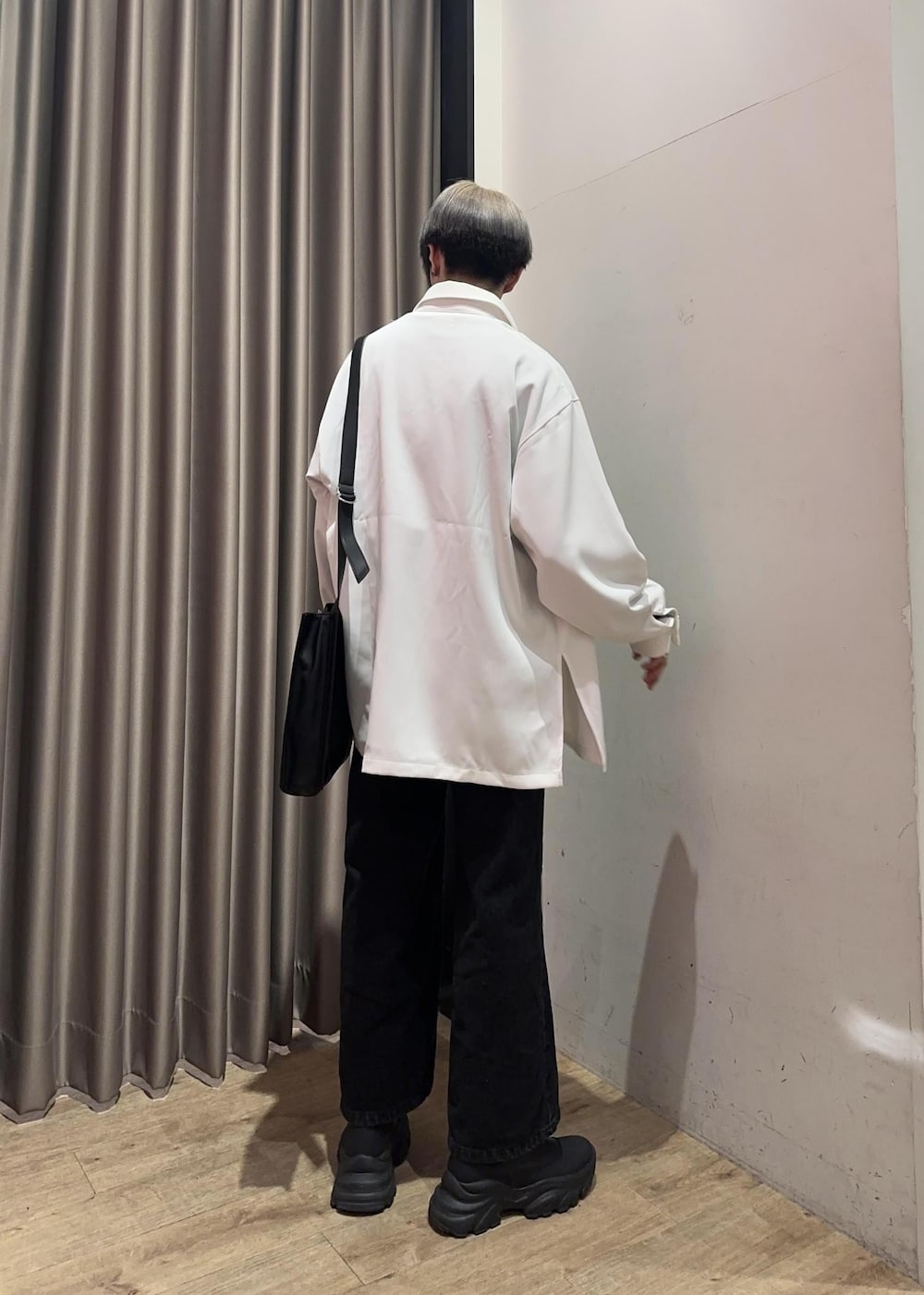 ブラック系のショルダーバッグ、ブラック系のスウェット、ブラック系のデニムパンツを着用したメンズの冬コーディネートの3枚目の写真