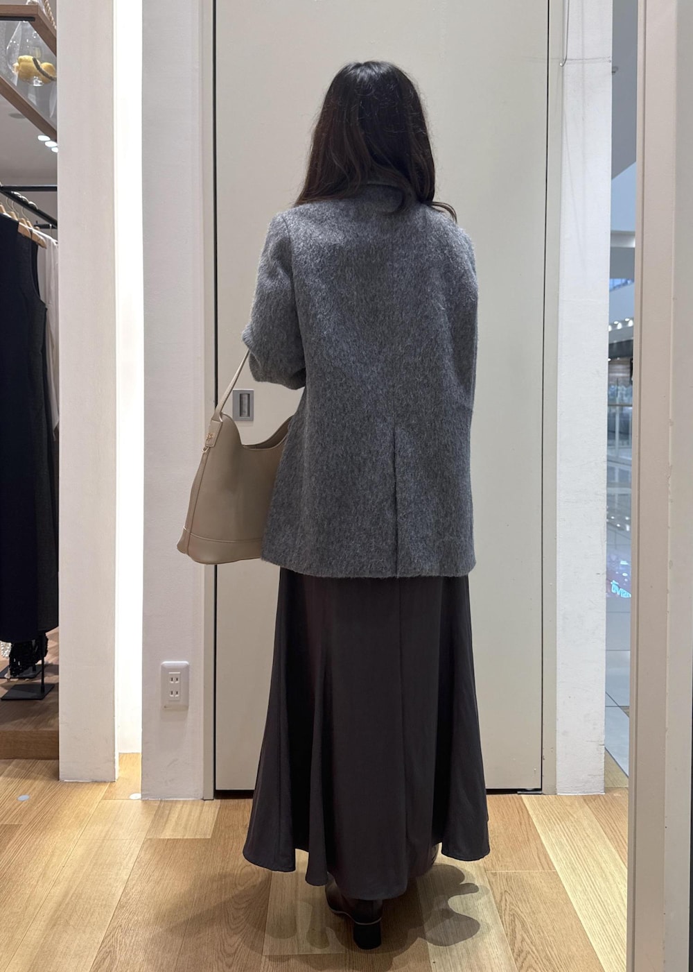 グレー系のスカート、グリーン系のニット/セーター、グレー系のテーラードジャケットを着用したレディースの秋コーディネートの3枚目の写真
