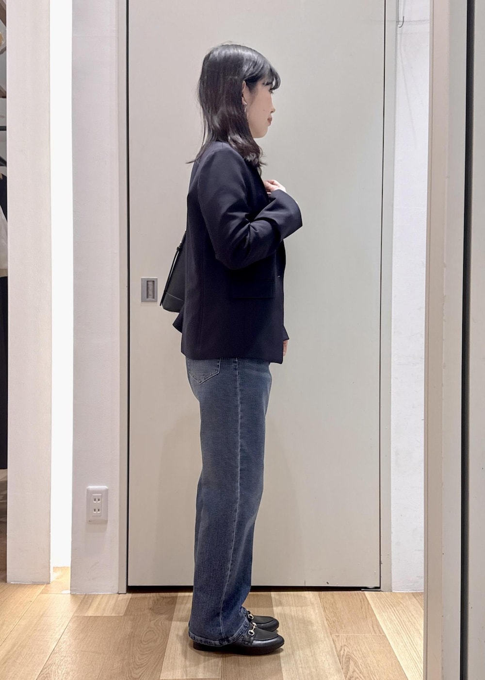 ブラック系のショルダーバッグ、ブラック系のローファー、ブルー系のテーラードジャケットを着用したレディースの冬コーディネートの2枚目の写真