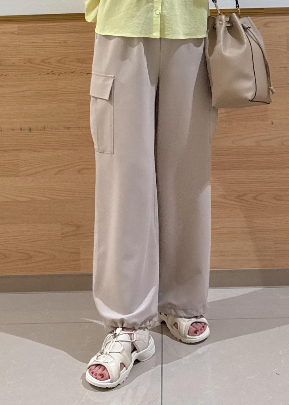 ホワイト系のサンダル、ベージュ系のカーゴパンツ、ベージュ系のショルダーバッグを着用したレディースの夏コーディネートの7枚目の写真