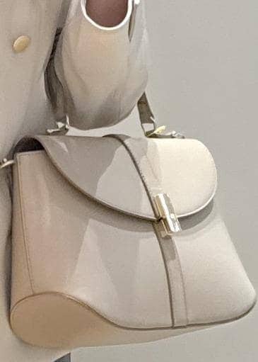 ベージュ系のパンプス、ベージュ系のショルダーバッグ、ブルー系のスカートを着用したレディースの春コーディネートの7枚目の写真