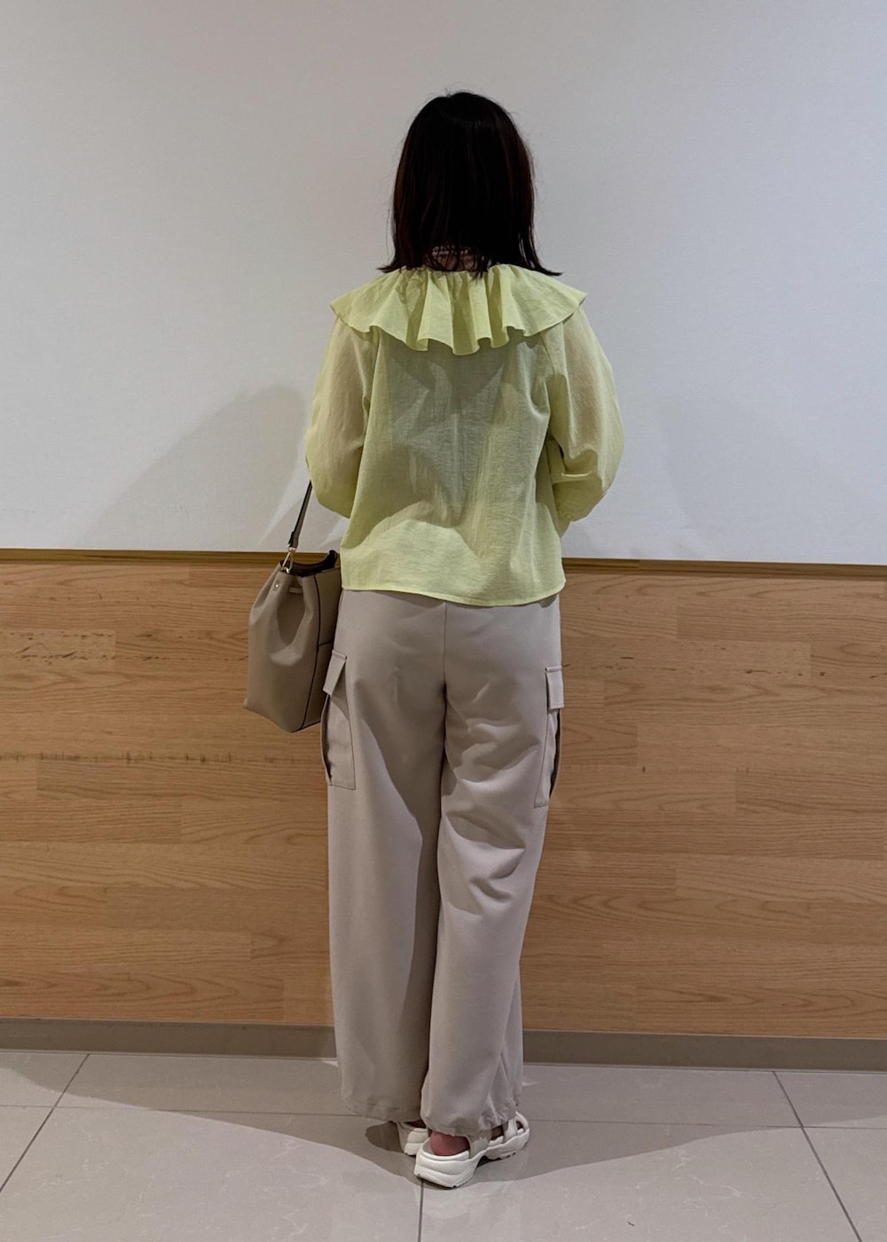 ホワイト系のサンダル、ベージュ系のカーゴパンツ、ベージュ系のショルダーバッグを着用したレディースの夏コーディネートの5枚目の写真