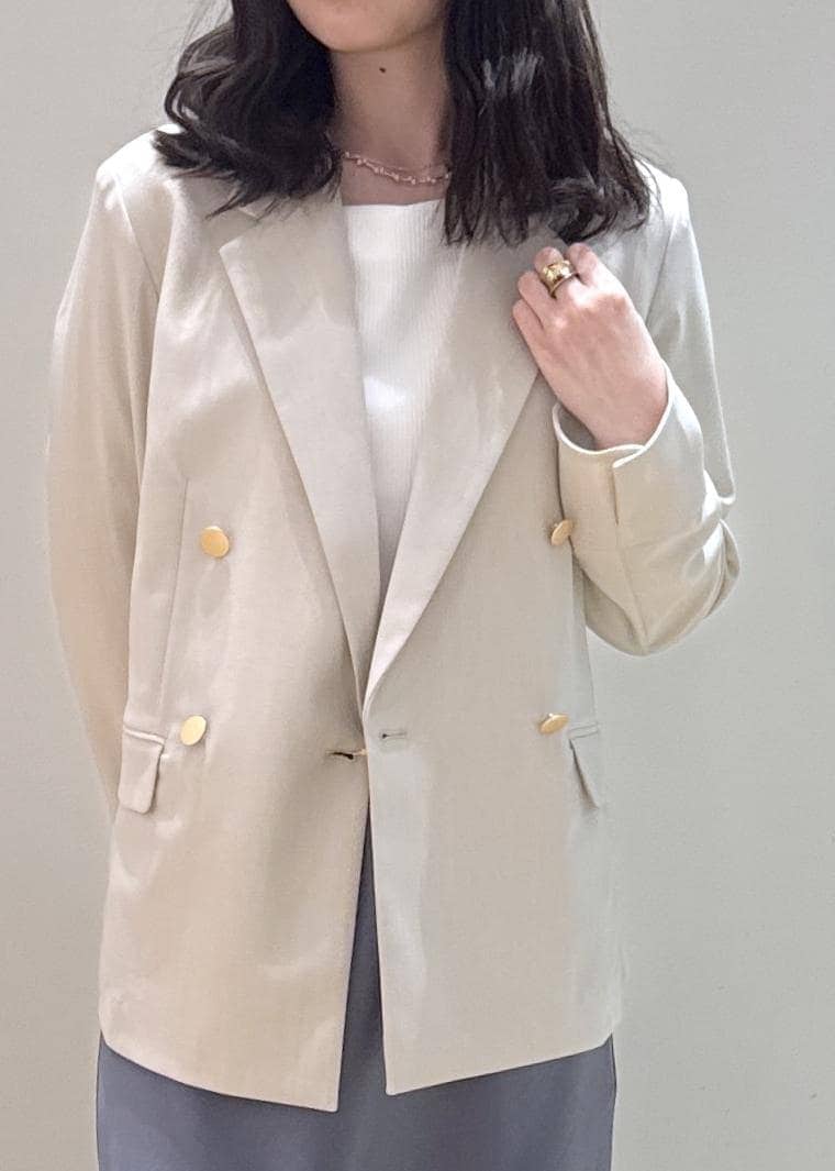 ベージュ系のパンプス、ベージュ系のショルダーバッグ、ブルー系のスカートを着用したレディースの春コーディネートの3枚目の写真