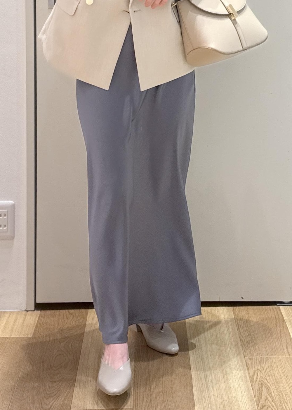 ベージュ系のパンプス、ベージュ系のショルダーバッグ、ブルー系のスカートを着用したレディースの春コーディネートの5枚目の写真