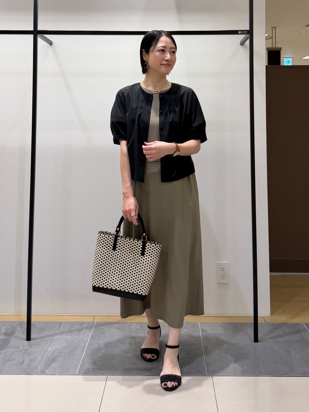 ブラック系のシャツ/ブラウス、グリーン系のワンピース、ブラック系のトートバッグを着用したレディースの夏コーディネートの3枚目の写真