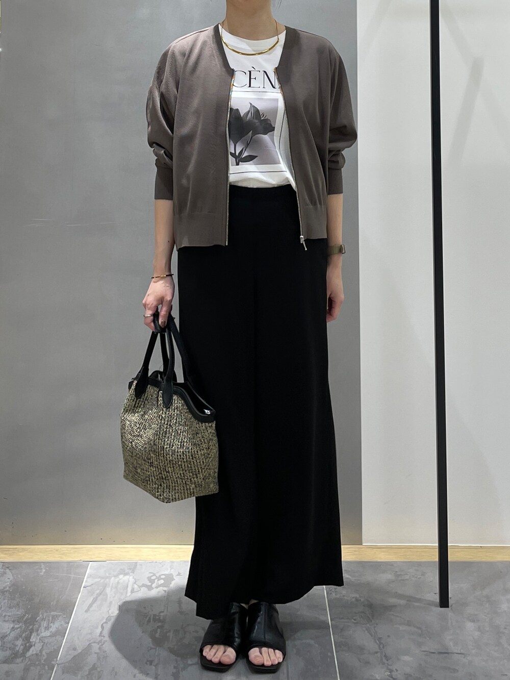 ブラック系のその他パンツ、ブラック系のトートバッグ、ブラウン系のカーディガン/ボレロを着用したレディースの春コーディネートの3枚目の写真