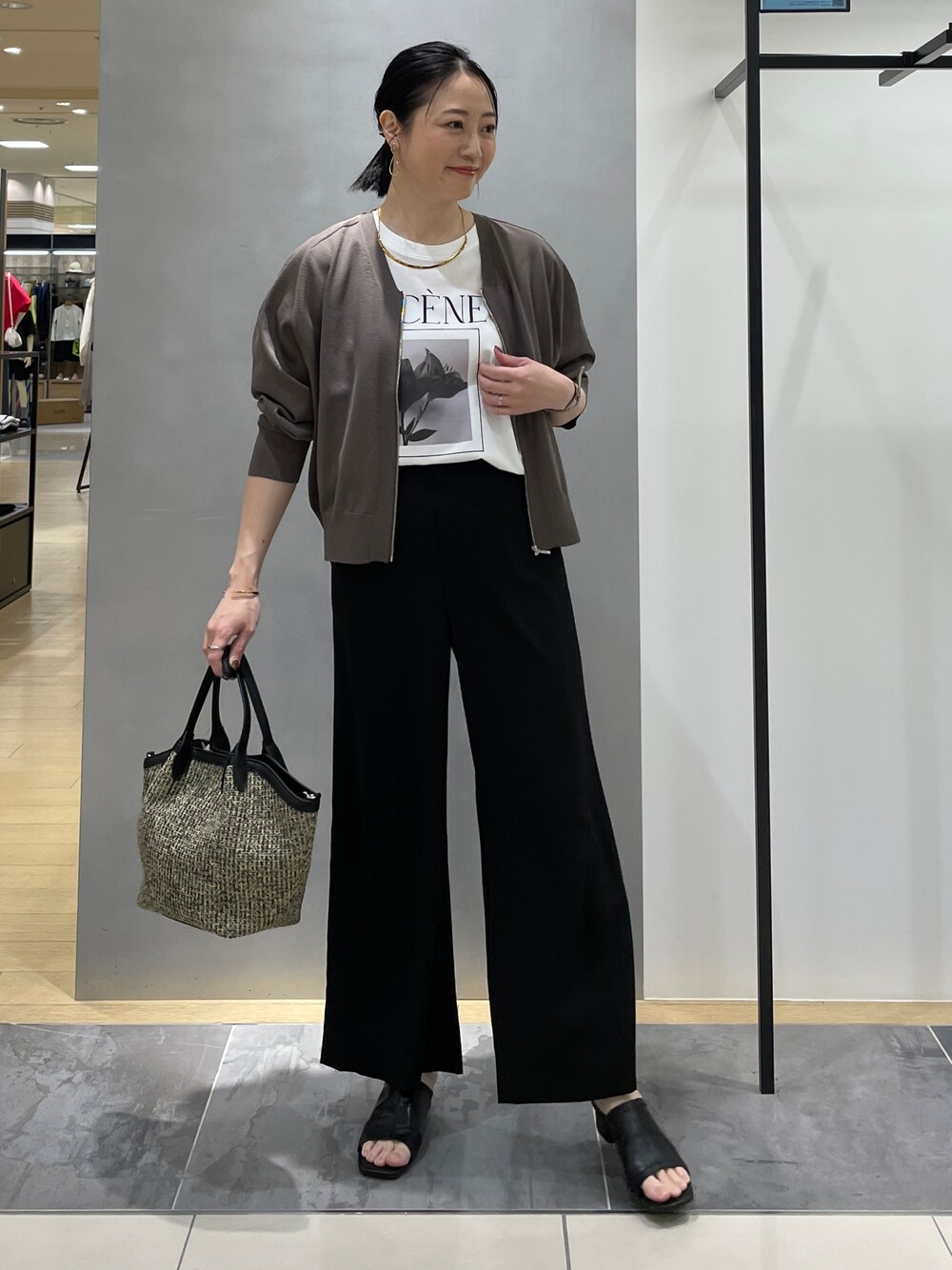 ブラック系のその他パンツ、ブラック系のトートバッグ、ブラウン系のカーディガン/ボレロを着用したレディースの春コーディネートの2枚目の写真
