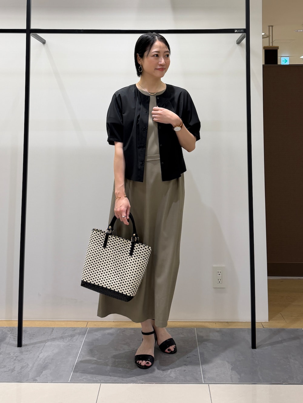 ブラック系のシャツ/ブラウス、グリーン系のワンピース、ブラック系のトートバッグを着用したレディースの夏コーディネートの2枚目の写真
