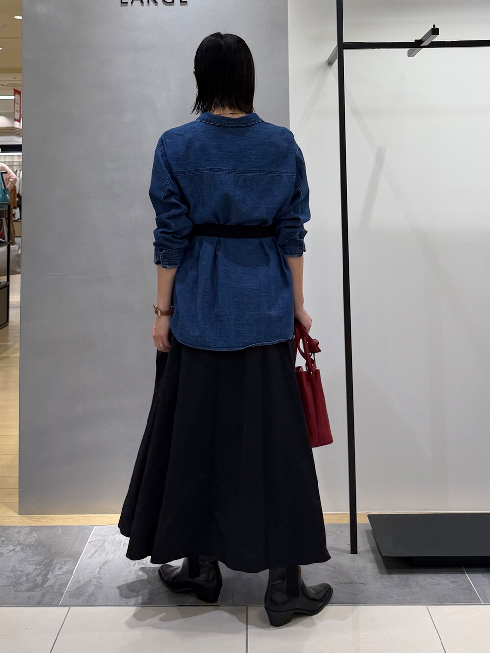 ブルー系のシャツ/ブラウス、ブラック系のスカート、レッド系のショルダーバッグを着用したレディースの秋コーディネートの6枚目の写真