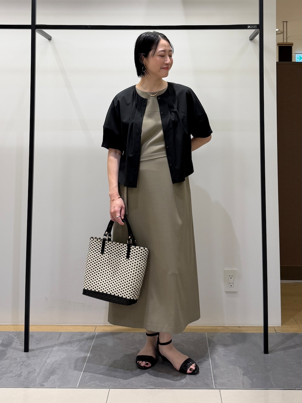 ブラック系のシャツ/ブラウス、グリーン系のワンピース、ブラック系のトートバッグを着用したレディースの夏コーディネートの6枚目の写真