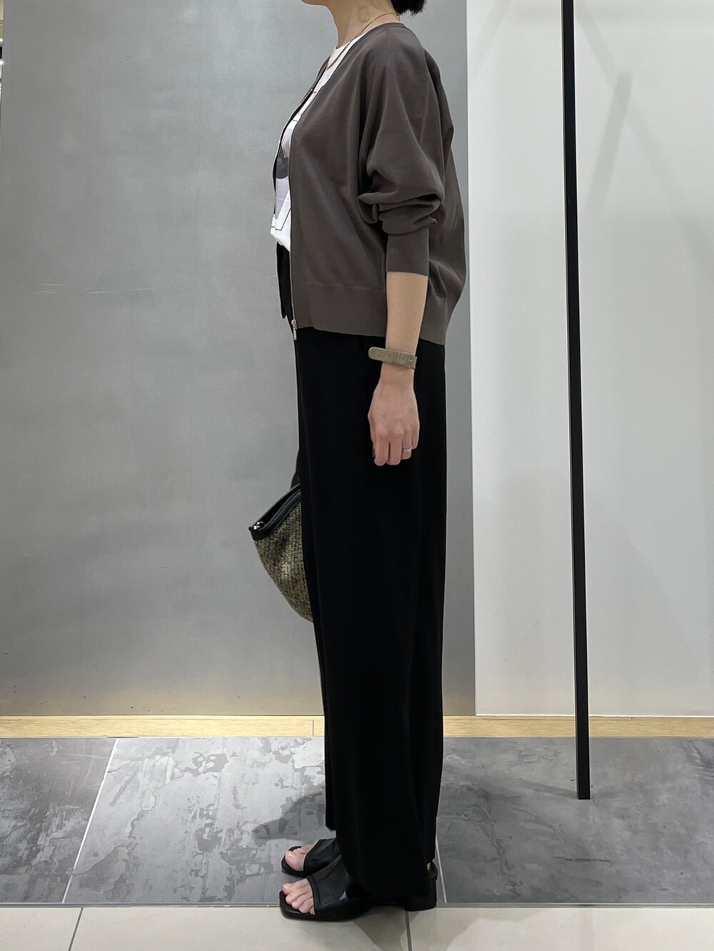 ブラック系のその他パンツ、ブラック系のトートバッグ、ブラウン系のカーディガン/ボレロを着用したレディースの春コーディネートの4枚目の写真