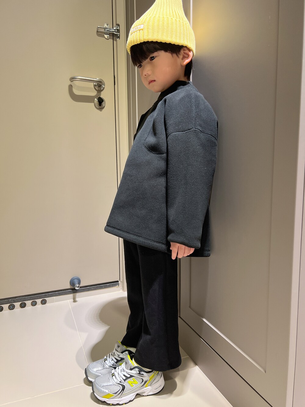 ブラック系のその他トップス、ブラック系のチノパンツ、グレー系のスニーカーを着用したキッズの冬コーディネートの2枚目の写真