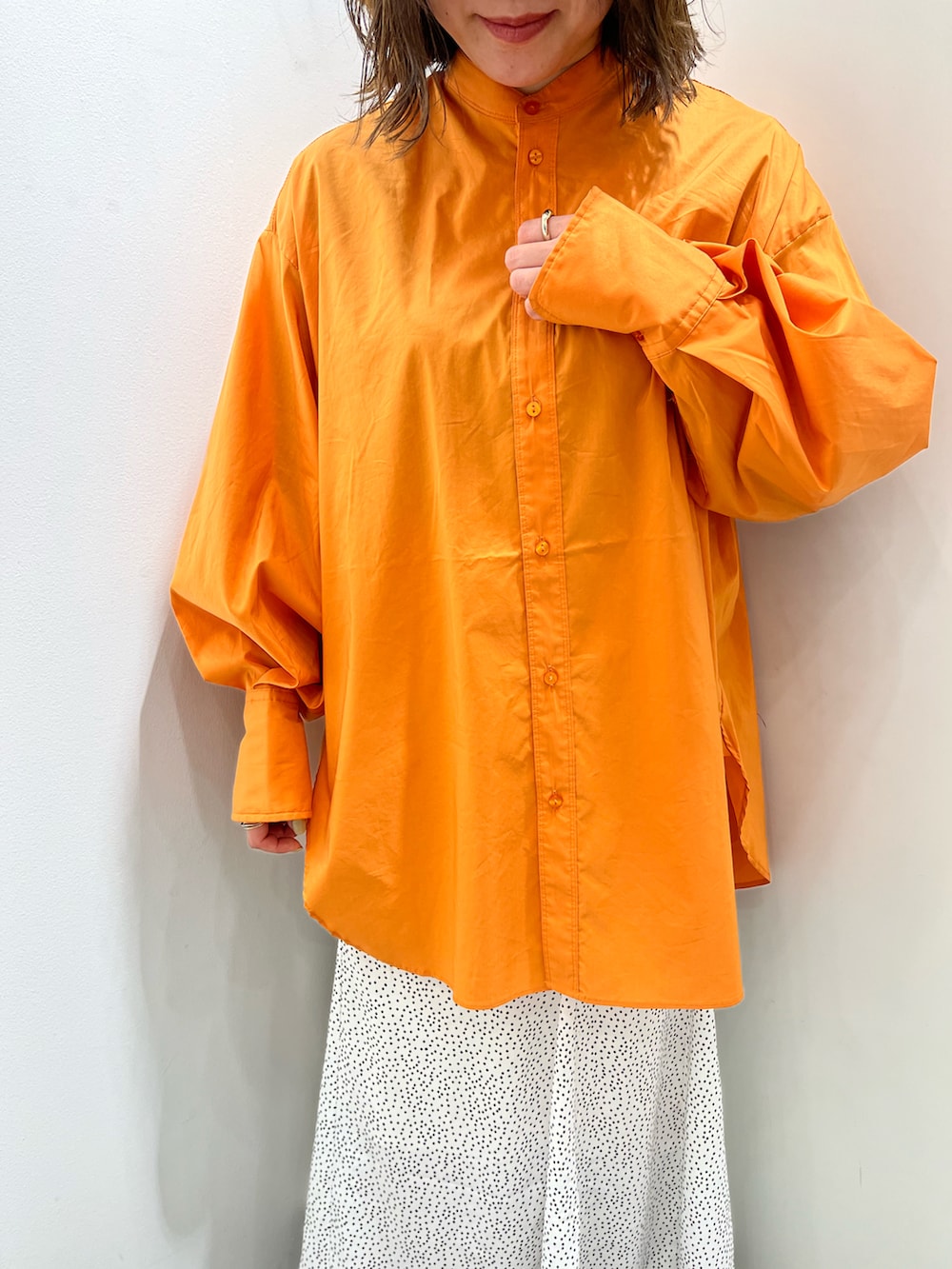 ベージュ系のショルダーバッグ、オレンジ系のシャツ/ブラウス、ホワイト系のスカートを着用したレディースの春コーディネートの4枚目の写真