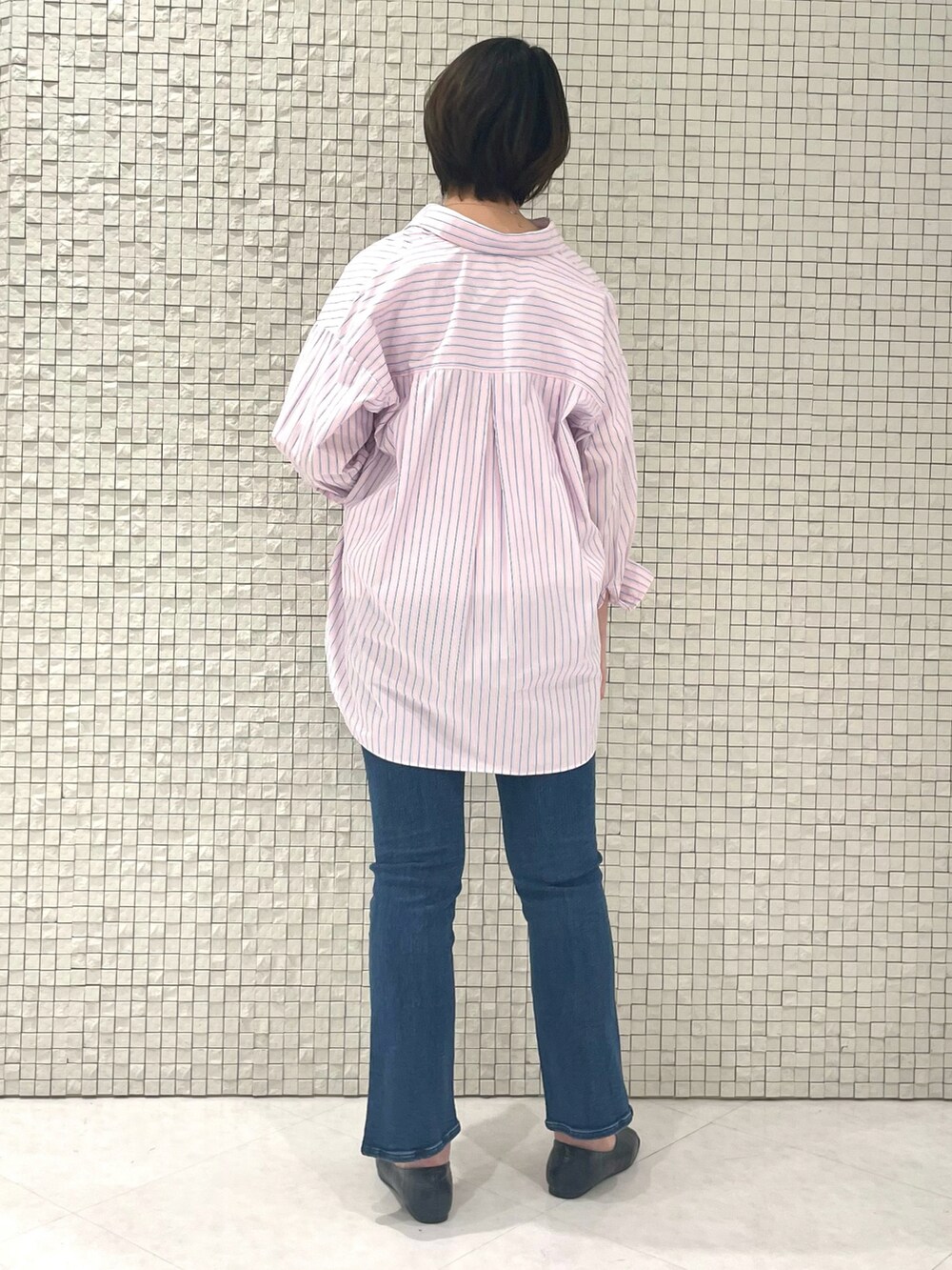 ピンク系のシャツ/ブラウス、ホワイト系のTシャツ/カットソー、ブルー系のデニムパンツを着用したレディースの春コーディネートの3枚目の写真