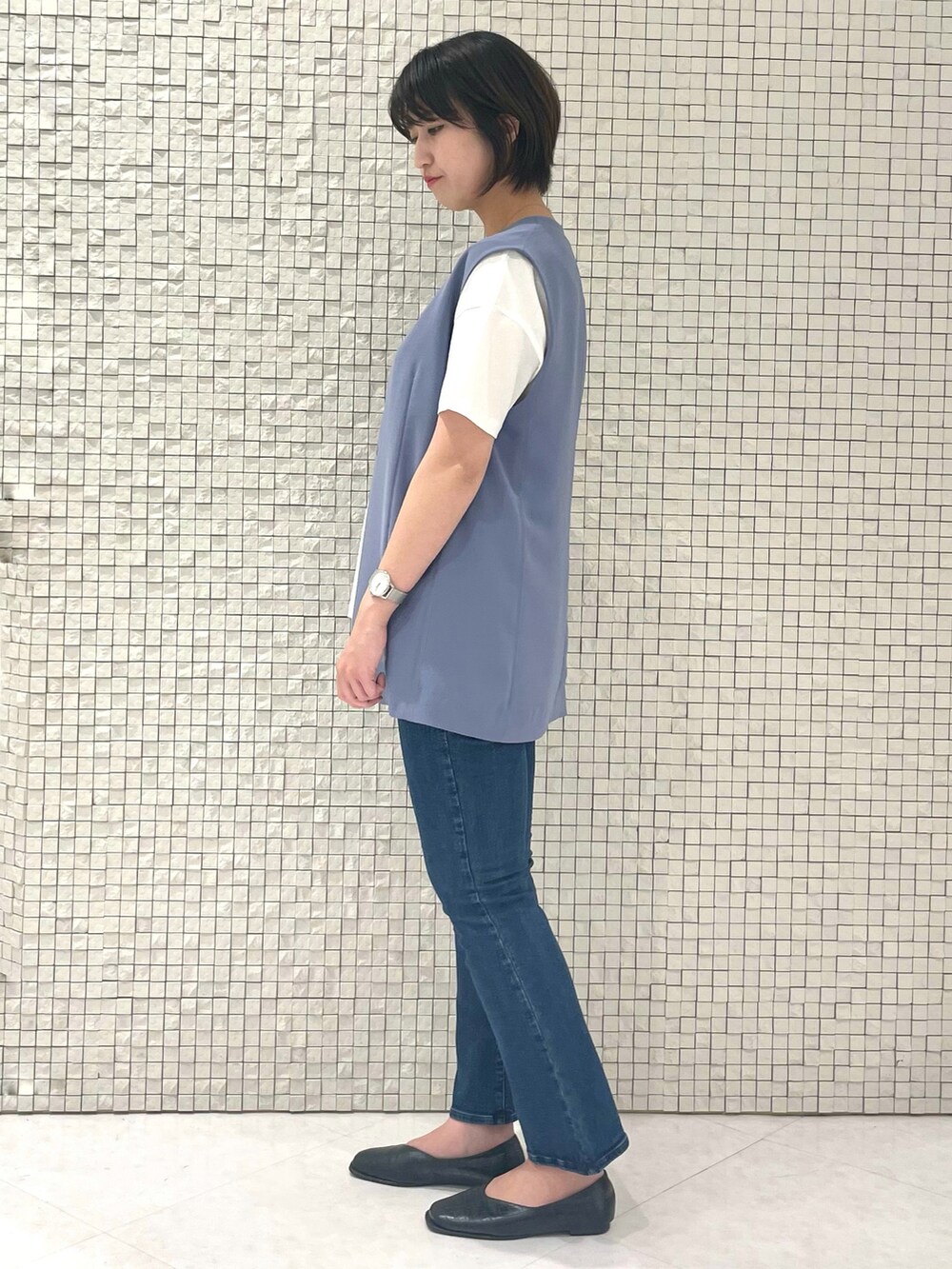 ホワイト系のTシャツ/カットソー、ブルー系のベスト、ブルー系のデニムパンツを着用したレディースの春コーディネートの2枚目の写真