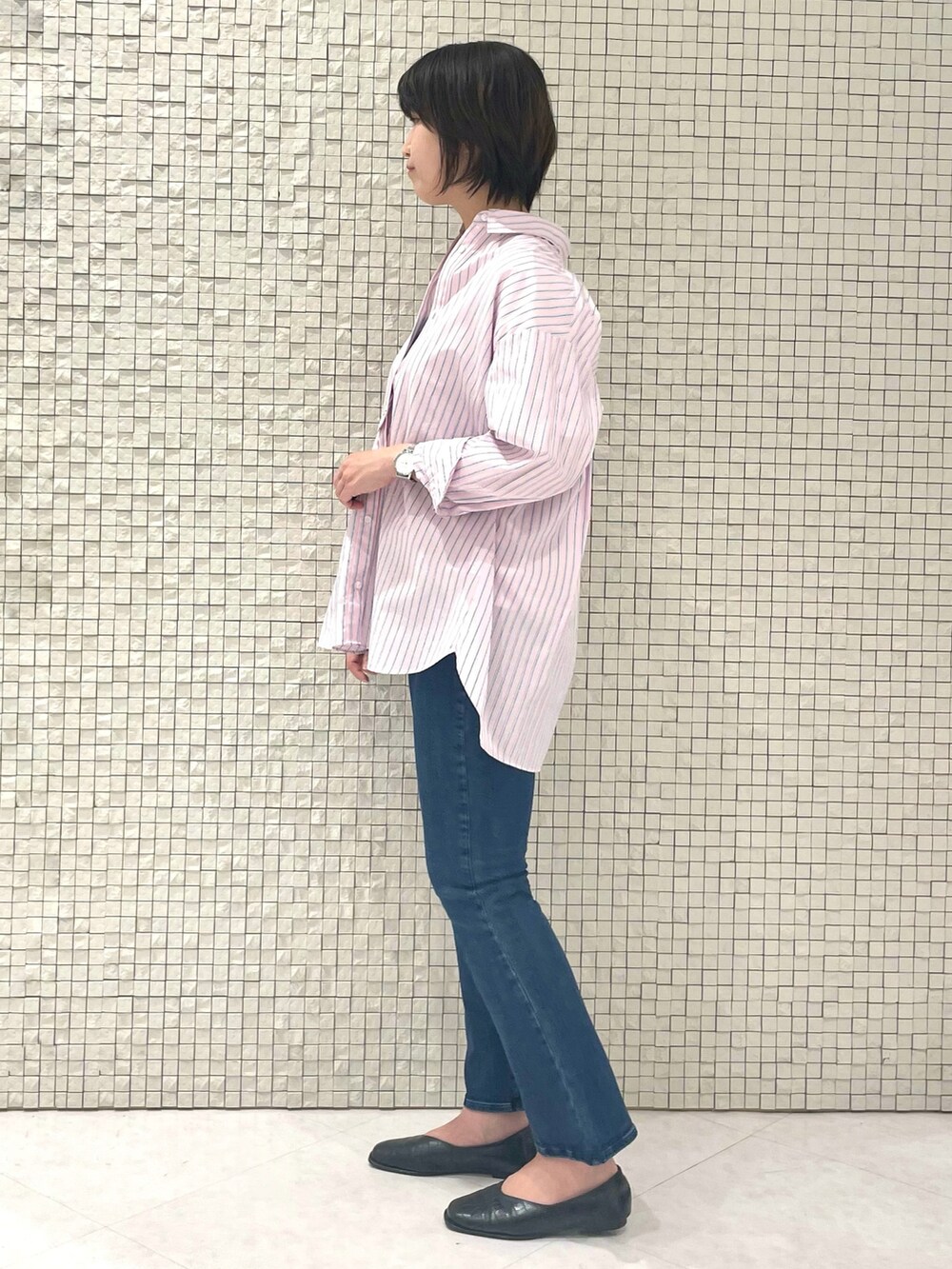 ピンク系のシャツ/ブラウス、ホワイト系のTシャツ/カットソー、ブルー系のデニムパンツを着用したレディースの春コーディネートの2枚目の写真