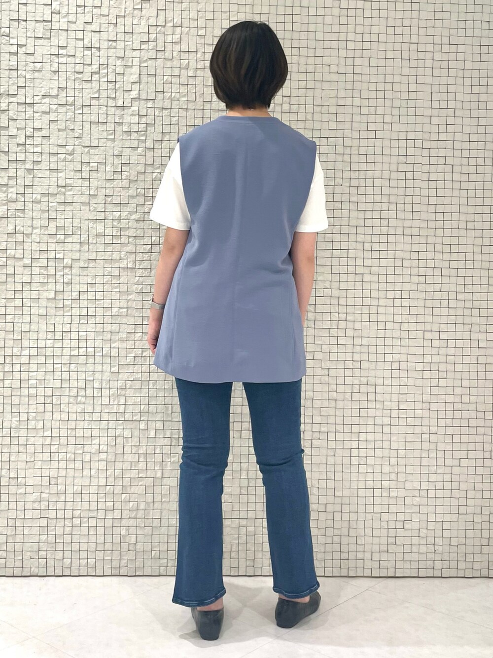 ホワイト系のTシャツ/カットソー、ブルー系のベスト、ブルー系のデニムパンツを着用したレディースの春コーディネートの3枚目の写真